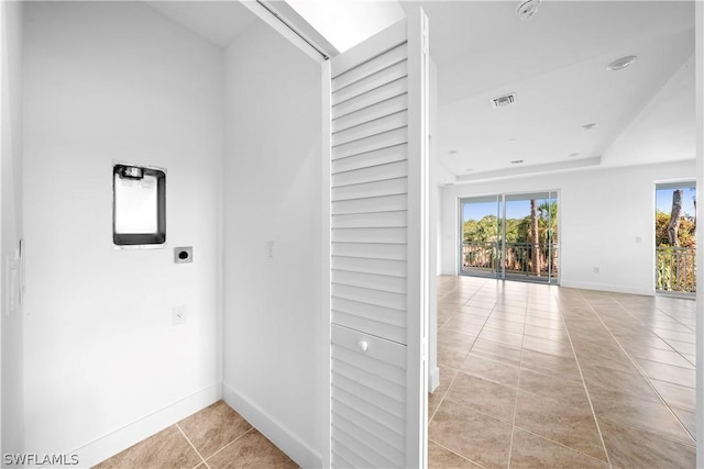 hallway featuring light tile patterned floors, baseboards, and visible vents