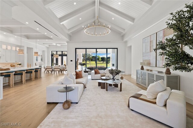 living room with high vaulted ceiling, beam ceiling, light wood-style flooring, and an inviting chandelier