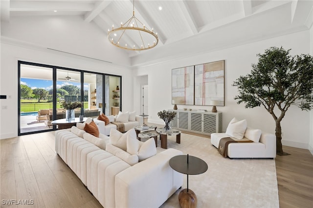 living room featuring high vaulted ceiling, a notable chandelier, wood finished floors, baseboards, and beam ceiling