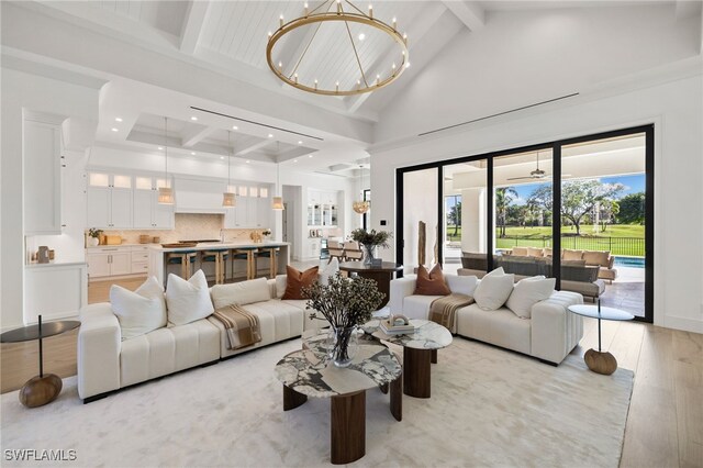 living room featuring beam ceiling, high vaulted ceiling, recessed lighting, light wood-style flooring, and a chandelier