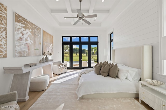 bedroom with access to exterior, beam ceiling, french doors, wood finished floors, and coffered ceiling