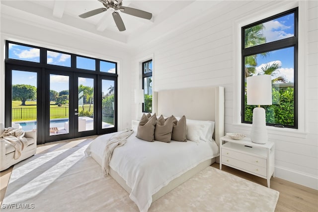 bedroom featuring ceiling fan, wood finished floors, baseboards, access to exterior, and french doors