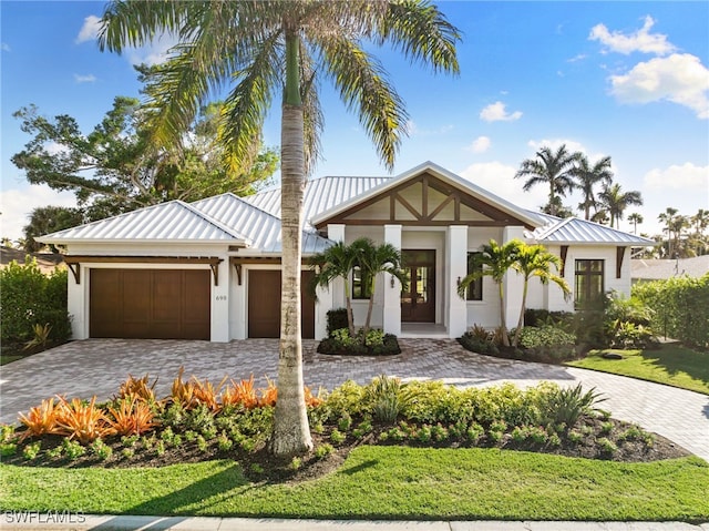 view of front of home with a garage, a standing seam roof, metal roof, and decorative driveway