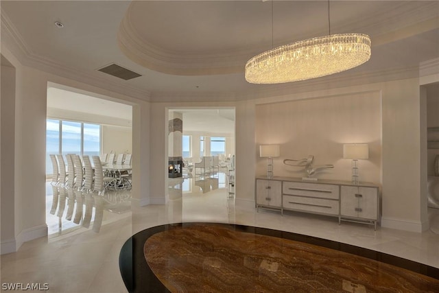 interior space with marble finish floor, crown molding, a raised ceiling, visible vents, and baseboards