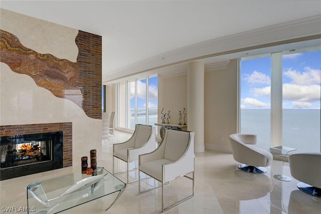 interior space with a water view, baseboards, ornamental molding, and a multi sided fireplace