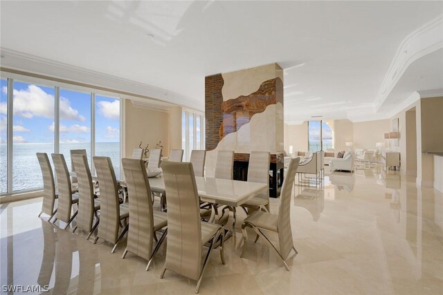 dining space with light tile patterned flooring, a water view, crown molding, and a healthy amount of sunlight