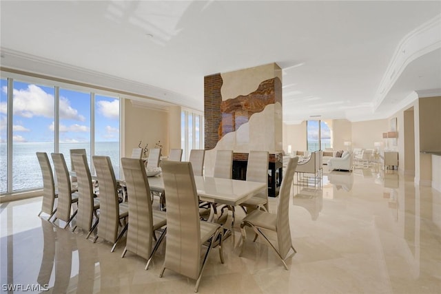 dining area featuring ornamental molding, marble finish floor, and a water view