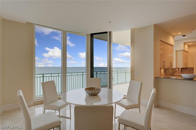 dining room featuring a water view and light tile patterned floors