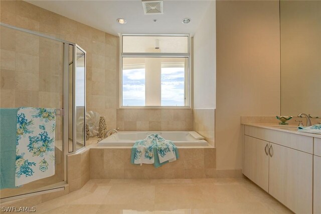 bathroom featuring tile patterned flooring, plus walk in shower, and vanity