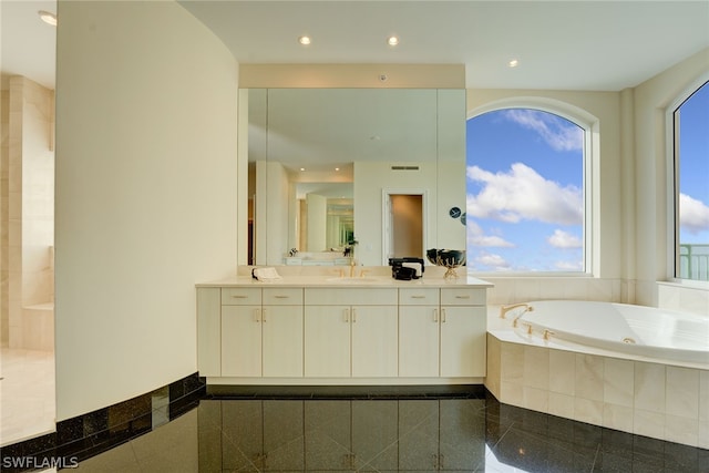 bathroom featuring vanity, tiled bath, and tile patterned floors