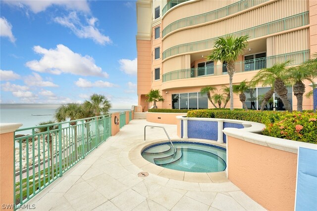 view of pool featuring a water view and a community hot tub