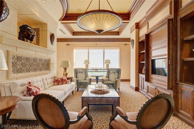 carpeted living room with crown molding, built in shelves, and a tray ceiling