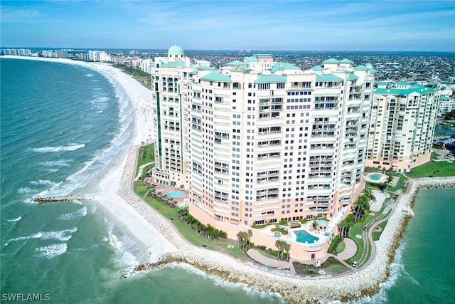 birds eye view of property with a water view and a beach view