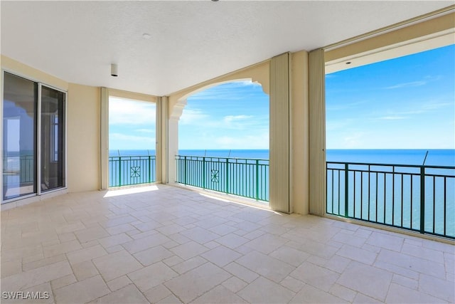 view of patio with a water view and a balcony