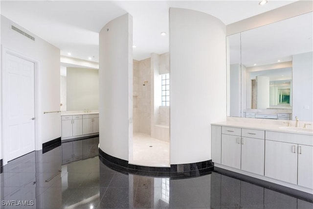 full bathroom with visible vents, granite finish floor, a sink, tiled shower, and baseboards