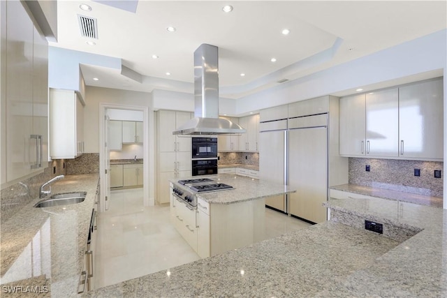 kitchen featuring paneled refrigerator, a sink, visible vents, island exhaust hood, and stainless steel gas stovetop