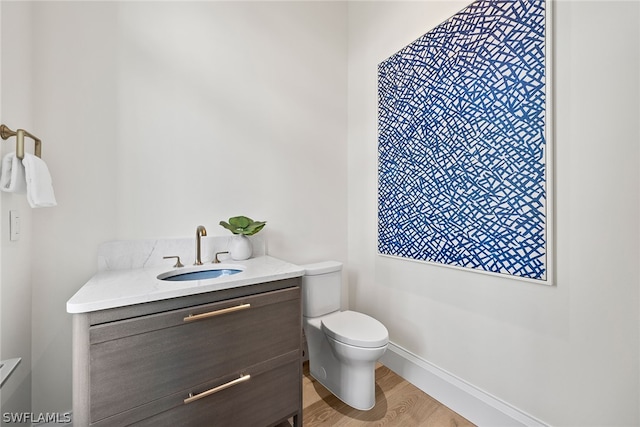 bathroom featuring wood-type flooring, vanity, and toilet