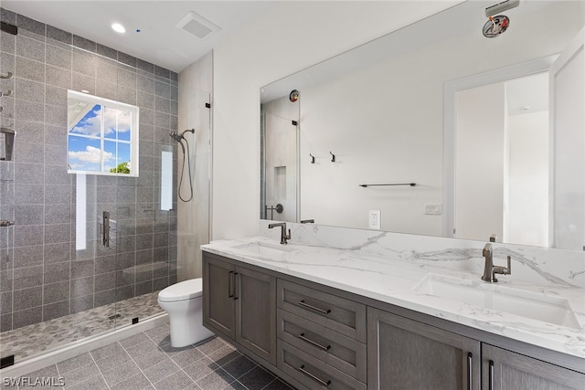 bathroom featuring walk in shower, tile floors, toilet, and double sink vanity