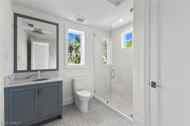 bathroom with plenty of natural light, large vanity, a shower with shower door, and tile floors