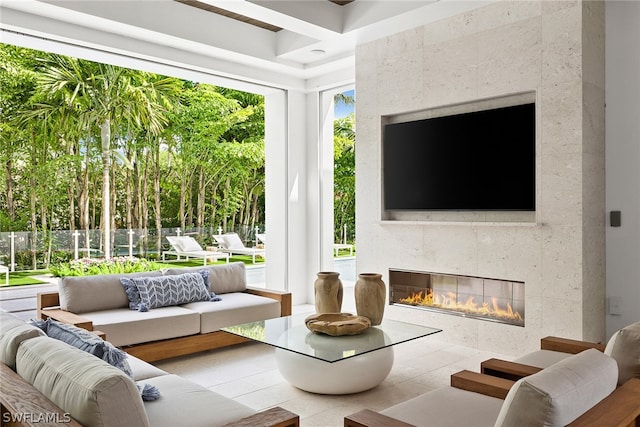 living room featuring tile flooring, a wealth of natural light, and a tiled fireplace