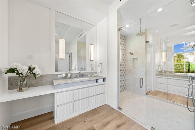 bathroom featuring wood-type flooring, a shower with door, and vanity