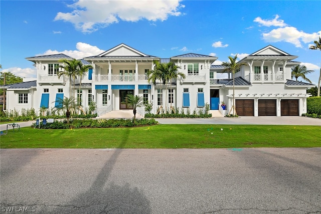 view of front facade with french doors, a balcony, a front lawn, and a garage