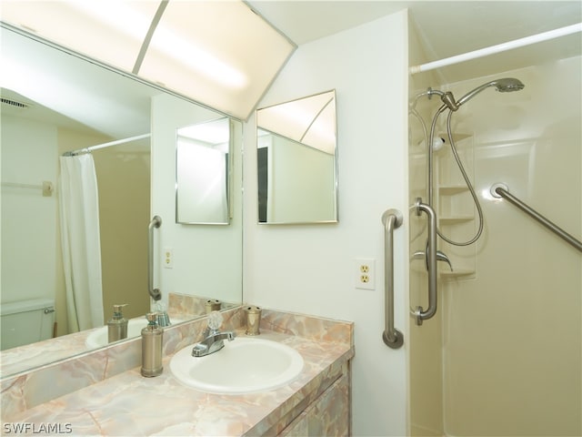 bathroom with curtained shower, toilet, and vanity