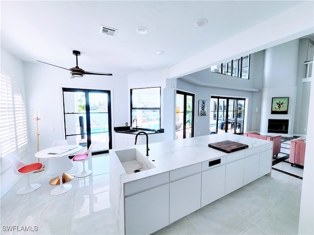 kitchen featuring white cabinetry, french doors, a healthy amount of sunlight, and ceiling fan