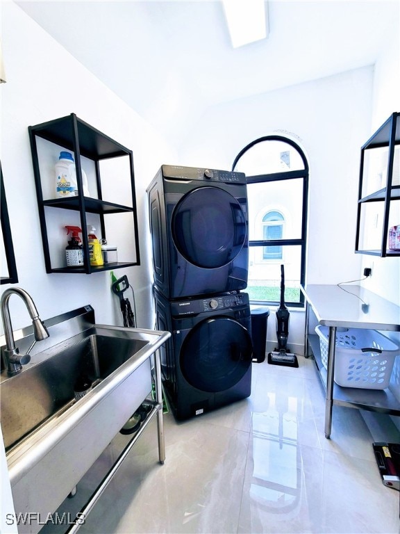 clothes washing area featuring stacked washer / dryer and sink