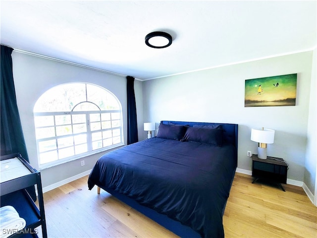 bedroom with crown molding and light hardwood / wood-style flooring