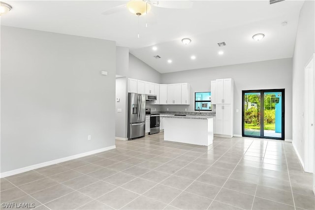 kitchen featuring light tile floors, white cabinets, stainless steel appliances, light stone countertops, and a center island