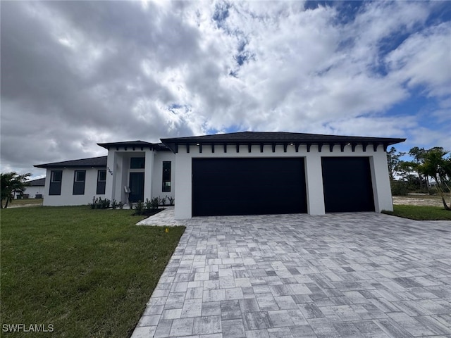 view of front of house with a front yard, decorative driveway, an attached garage, and stucco siding