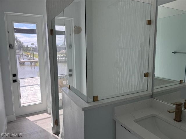 bathroom featuring wood finished floors, vanity, and a water view