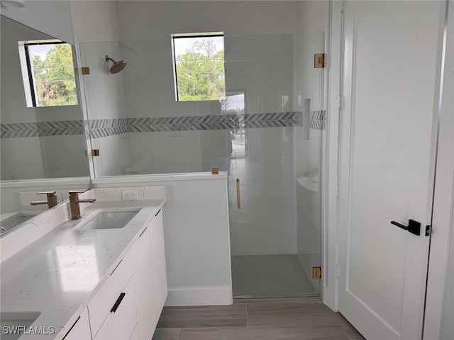 full bathroom with tiled shower and vanity