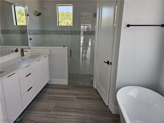 full bath with a shower stall, a freestanding tub, a healthy amount of sunlight, and a sink