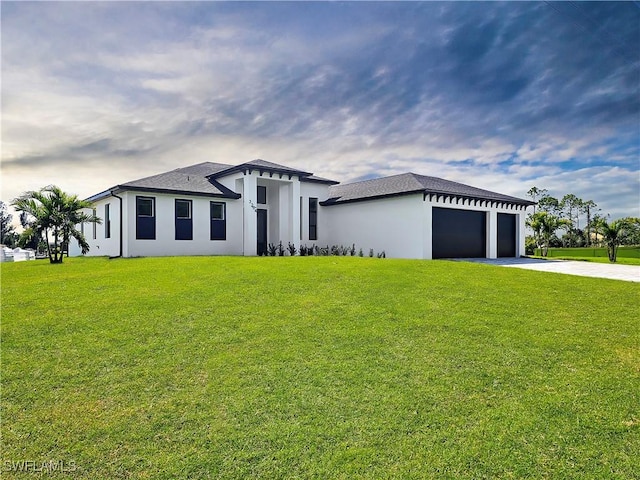 prairie-style home featuring stucco siding, driveway, an attached garage, and a front lawn