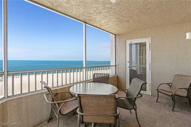 sunroom with a beach view and a water view