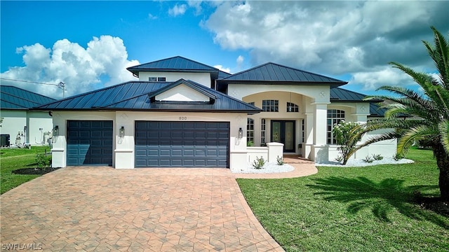 view of front of home with french doors, a front lawn, and a garage