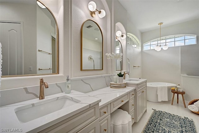 bathroom with tile patterned flooring, vanity, and a tub