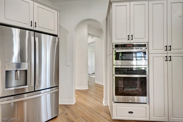 kitchen featuring light wood-type flooring, stainless steel appliances, and white cabinetry