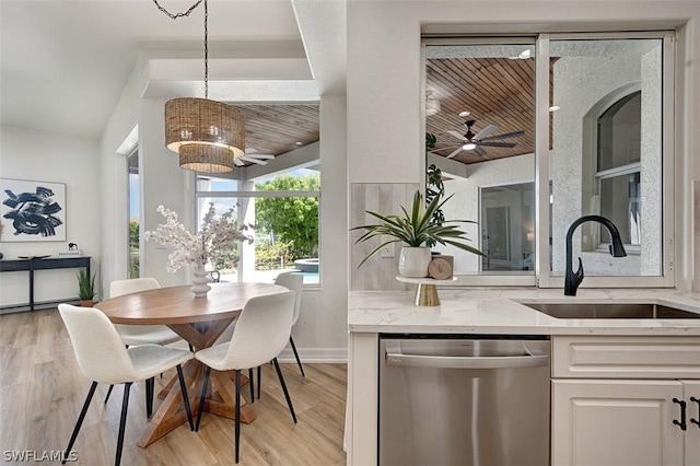 dining space featuring ceiling fan with notable chandelier, light hardwood / wood-style floors, and sink