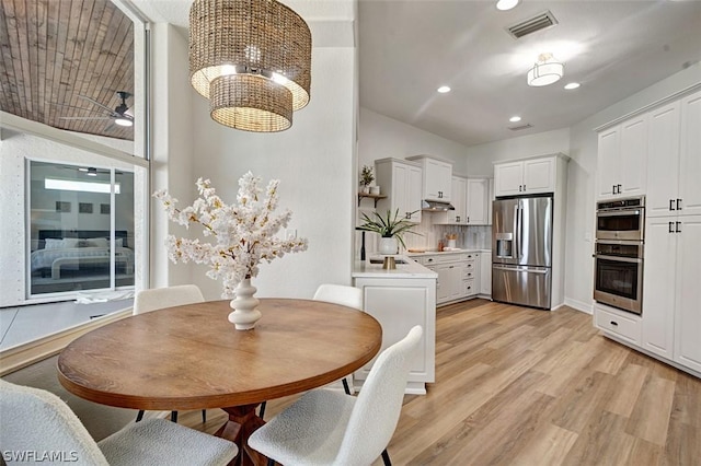 dining area with light hardwood / wood-style flooring and ceiling fan