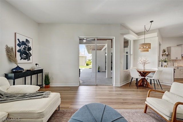 living room with ceiling fan and light wood-type flooring