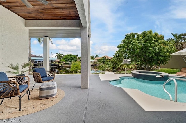 view of pool featuring an in ground hot tub, a water view, ceiling fan, and a patio area