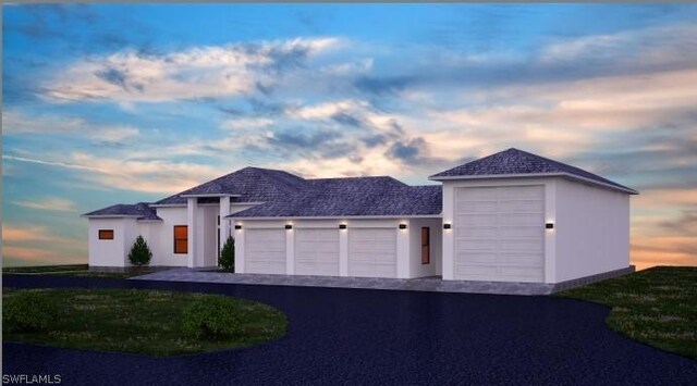 view of front facade featuring an attached garage, aphalt driveway, and stucco siding