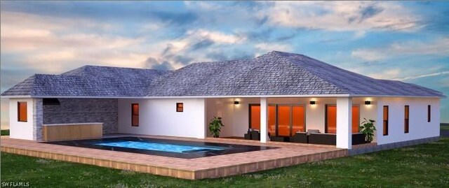 back of house featuring stone siding, stucco siding, and an in ground hot tub