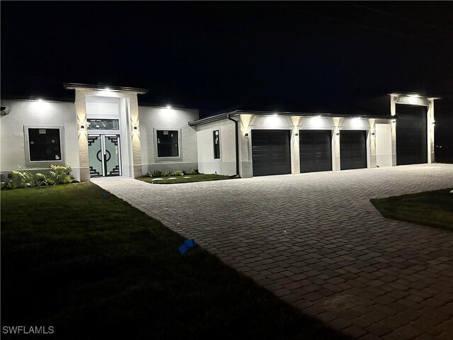 view of front of home featuring decorative driveway and stucco siding