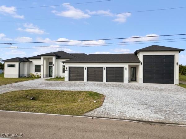 prairie-style home featuring a garage, a front yard, and decorative driveway