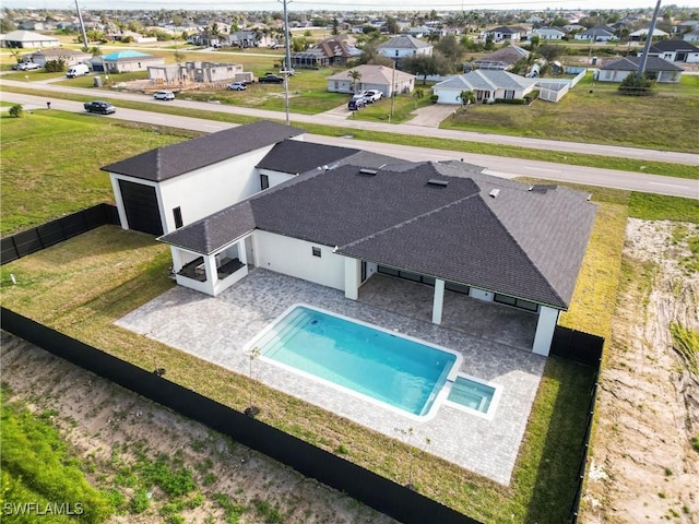 view of pool featuring a patio, a pool with connected hot tub, a fenced backyard, and a residential view