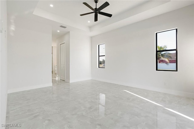 unfurnished room with recessed lighting, a raised ceiling, visible vents, and plenty of natural light